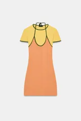 Vestido corto de algodón con diseño de efecto doble, compuesto por una base color naranja y una capa superior tipo remera amarilla con cuello halter y detalles de vivos en color verde.
