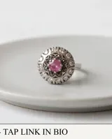 Anillo de plata 925 con piedra natural de raíz de rubí en el centro, rodeada por circonias cúbicas y detalles oscurecidos.