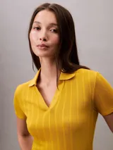 Chomba de punto pointelle texturizado color amarillo, con cuello tipo Johnny abierto, manga corta y ribetes en canalé. Presenta un diseño minimalista con logo bordado sutil en la parte frontal.