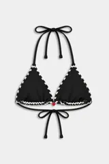 Top de bikini tipo triángulo de tirantes finos negros, con patrón de ondas blancas y negras en relieve. Presenta un pequeño dije en forma de corazón en el centro.
