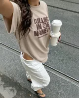 Remera oversize color beige con efecto acid wash y estampa frontal en marrón con la frase "Killing In The Name Of".