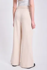 Pantalón de lino color crudo, de corte palazzo y tiro alto.