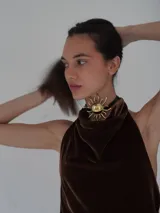 Collar tipo choker con tira de cuero marrón y dije central de sol grande en bronce, con terminación de tira larga y detalle metálico colgante.