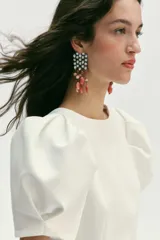 Pendientes tipo cascada con estructura superior geométrica decorada con cristales y flecos inferiores compuestos por piedras naturales en tonos coral y ámbar.