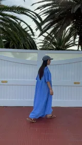 Vestido largo celeste de lino, con escote en V y corte debajo del busto.