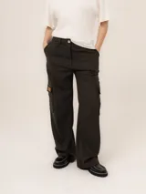 Pantalón cargo de corte recto y tiro alto, color beige con estampado de rayas verticales finas. Presenta bolsillos laterales tipo cargo con solapa y parche de cuero con logo de la marca.