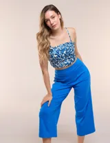 Pantalón capri azul de corte recto y largo crop, con cintura alta elastizada y bolsillos delanteros aplicados con borde festoneado.