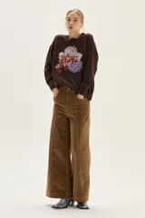 Pantalón de pana de corte recto y pierna ancha, color camel, con bolsillos frontales y costuras verticales decorativas en el frente.