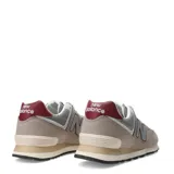 Championes urbanos New Balance modelo 574, color gris con detalles en bordó y blanco. Confeccionados en gamuza y malla, con el logo N característico en los laterales y entresuela con tecnología ENCAP.