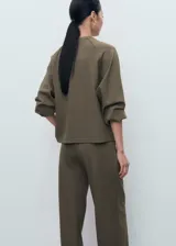 Buzo de cuello redondo y manga larga con diseño recto y holgado, confeccionado en tejido de punto suave.