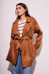 Trench marrón de gamuza vegana con cuello solapa, manga larga, cinturón con hebilla y corte evasé.