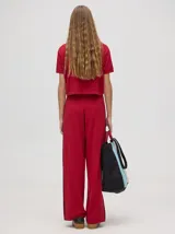 Pantalón de algodón color rojo, de corte holgado y pierna ancha, con pretina elástica y rayas bicolores al costado.