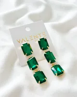 Aros colgantes con tres gemas rectangulares de color verde esmeralda con engarce dorado.