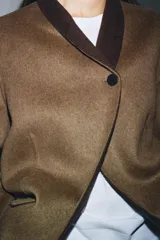 Blazer oversize de Zara Woman Collection confeccionado en mezcla de lana, con cuello sin solapa, manga larga y cierre frontal con botón. Presenta bolsillos delanteros con solapa.