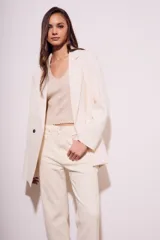 Blazer color crema de poliéster y viscosa, de corte oversize con solapas y doble botonadura.