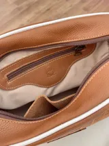 Correa de repuesto para cartera, de tela color beige con rayas blancas y negras. Incluye herrajes metálicos color bronce y apliques de cuero sintético color marrón.