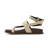 Sandalias planas Korium Adhara de cuero color marrón oscuro con tiras de gamuza en tono tostado. Presentan diseño de tira al dedo, tachas doradas y abalorios de piedras incrustadas, y tira ajustable al tobillo con hebilla metálica.