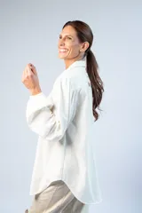 Camisa oversize color manteca con lúrex dorado, cuello clásico, mangas largas abullonadas con puños elásticos y cordón ajustable en el escote.