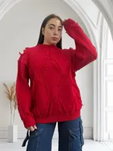 Sweater rojo de punto con cuello redondo y mangas largas. Presenta detalles de flecos en forma de rombos en el frente, la espalda y las mangas.