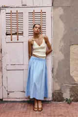 Falda midi celeste de popelina con cintura elástica y bolsillos laterales ocultos.