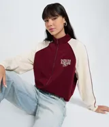 Saco femenino de poliviscosa color bordó con mangas raglán color crema y cuello alto. Presenta bordado lettering "Kansas City" en el pecho y cierre frontal con cremallera.