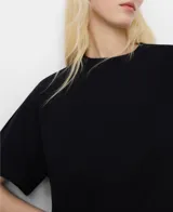 Camiseta blanca de algodón con corte evasé, cuello redondo y mangas cortas japonesas que caen sobre el codo.