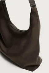 Bolso shopper marrón de hombro, con diseño liso, compartimento principal con cierre de cremallera y un bolsillo plano interior.
