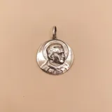 Medalla redonda de plata 925 con el perfil en relieve de San Juan Bosco, rodeado por un halo.