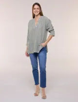 Blusa de silueta holgada a rayas verdes y blancas, confeccionada en tela liviana con textura arrugada. Presenta cuello en V profundo con botones frontales, mangas 3/4 de hombro caído y ruedo asimétrico con aberturas laterales.