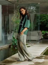 Pantalón de jean de lavado claro (oxido), corte ancho y tiro bajo, con cordones ajustables a la vista en la cintura y bordado en el frente.