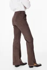 Pantalón de corte sastrero con textura aterciopelada, de tiro alto y pierna recta con tajos laterales en el ruedo.