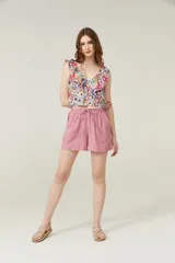 Blusa cropped con estampado multicolor, cuello redondo, sin mangas y volados en los hombros.