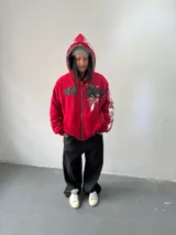 Campera reversible con cierre frontal, confeccionada en algodón de alto gramaje con estampa plastisol y bordado con aplique en un lado, y tela polar de pelo largo en el reverso. Presenta diseño oversize, capucha integrada y puños acanalados.