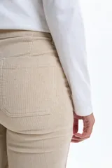 Pantalon de pana en color beige, de corte oxford con tiro medio y bolsillos frontales tipo parche. Confeccionado en tejido con elastano para mayor comodidad y ajuste.