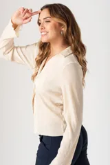 Camisa color crudo con diseño plisado, escote en V y tres botones.