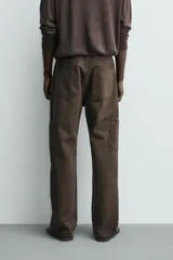 Pantalón cargo straight fit de algodón color negro con efecto lavado, bolsillos laterales en las piernas y cierre frontal con cremallera y botón.