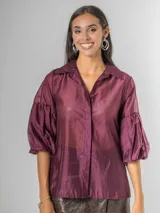 Camisa de organdí de algodón italiano en color bordó, con cuello camisero, cierre frontal con botones y mangas farol que aportan volumen.