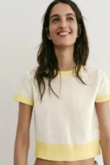 Top de punto color crudo con cuello redondo, manga corta y detalles de rib en color amarillo en el cuello, los puños y el ruedo.