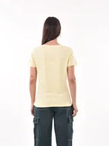 Remera negra de algodón con estampado frontal de la palabra "MERCI" en letras delineadas con colores del arcoíris.