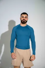 Remera deportiva de manga larga confeccionada en lycra color azul, de corte ajustado y diseño liso con costuras reforzadas.