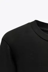 Body de manga larga con cuello redondo, confeccionado en una mezcla de algodón y modal. Presenta cierre inferior con botones a presión.