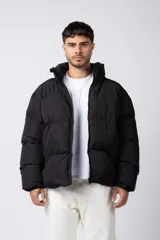 Campera puffer de corte relajado en color verde oscuro, con cuello alto, cierre frontal completo y logo bordado en el pecho.