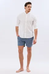 Short de baño color celeste con bordado de pequeñas palmeras, cintura elastizada y bolsillos laterales.