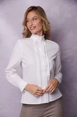 Camisa blanca de manga larga con cuello alto con volados y botones frontales.