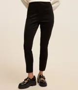 Pantalón tipo legging de tiro alto confeccionado en material sintético con recortes verticales y cierre lateral con cremallera.