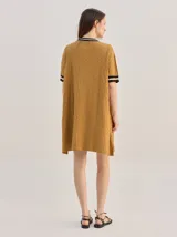 Vestido corto de algodón con estampa geométrica en tonos verde y amarillo, cuello redondo y mangas cortas con puños en color contrastante.