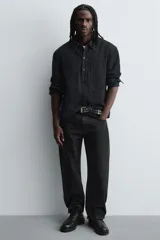 Bota tipo derby de cuero negro con cordones al tono, horma redonda y suela track con ligero tacón.