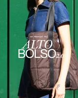 Bolso tipo tote de diseño urbano, confeccionado en material impermeable acolchado de color negro. Cuenta con doble asa de hombro, compartimento principal con cierre, bolsillo frontal con cierre y detalle de logo circular en la parte superior.