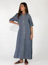 Vestido largo de lino color azul, con diseño estilo camisero, cuello camisero, cierre frontal con botones de madera y mangas largas con presilla para arremangar.