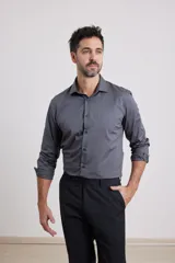 Camisa de vestir gris oscuro, de corte clásico, con cuello italiano y mangas largas con puños abotonados.